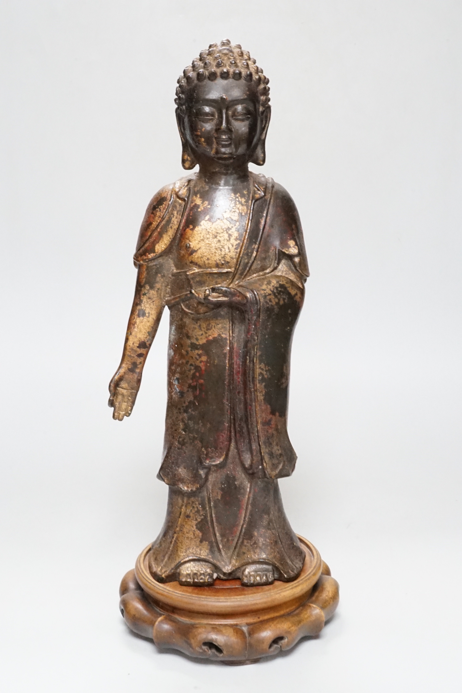 A Chinese gilt lacquered bronze standing figure of Buddha on stand, 31cm high not including stand